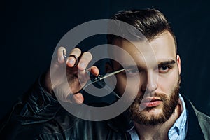 Young sexy man, portrait of guy with barber scissors for barber shop. Modern barbershop, shaving. Handsome male with
