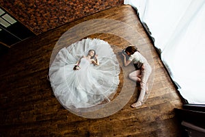 Young photographer is taking pictures the bride in the studio