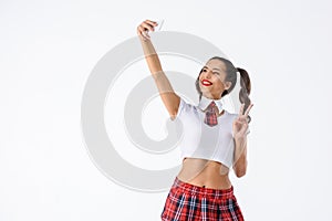 young schoolgirl taking selfie with peace gesture