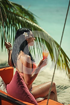 Young sexy woman with fresh drink in hands on beach, drink on exotic vacation