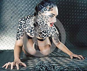 Young sexy woman with leopard make up all over body, cat bodyart print