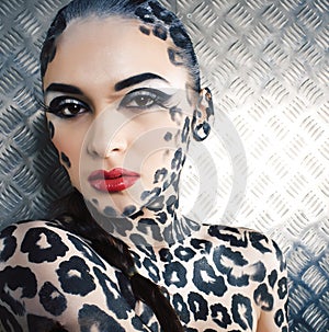 Young sexy woman with leopard make up all over body, cat bodyart print closeup