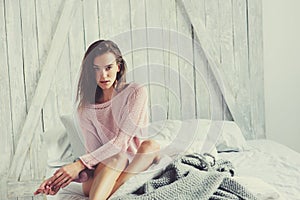 Young woman in pink lingerie relaxing at home in bed