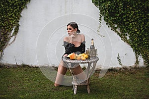 Young sexy woman relaxing and eating fruit outdoor. Exotic summer diet, tropical fruits. Beautiful romantic young woman