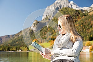 Woman is rowing with a rowing boat with a lake in the mountains