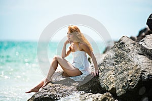 Young sexy woman at sea. Summer beach sensual girl. Girl in white dress on tropical beach vacation.