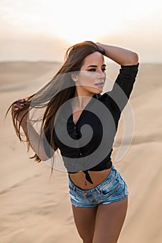 Young sexy woman walking on the dubai desert sand dunes