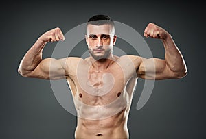 Athletic fighter posing on gray