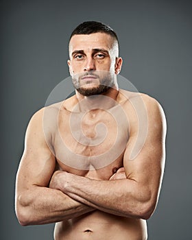 Athletic fighter posing on gray