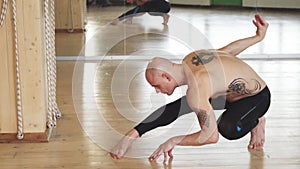 Young shirtless man practicing yoga indoors