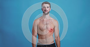 Young shirtless man with pulsating red spot on chest, heart disease