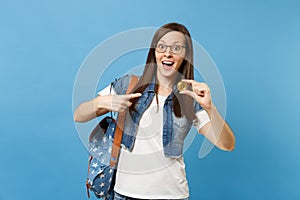 Young shocked excited woman student in glasses pointing index finger on bitcoin, metal coin of golden color isolated on