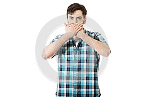 Young shocked man covering his mouth.