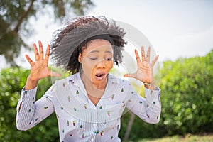 Young shocked woman looking down with a surprised expression on her face.