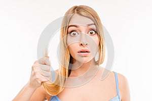 Young shocked woman showing her damaged split ends
