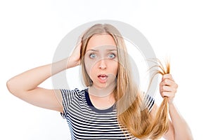 Young shocked woman showing her damaged split ends of hair