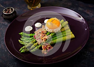 Young shoots of asparagus with ham and chicken egg yolk