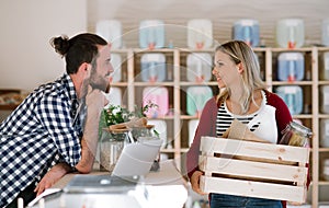 Young shop assistant serving an attractive woman in a zero waste shop.