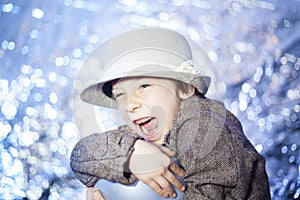Young short hair girl wearing a hat playing with a balloon in front of a sparkling bokeh backdrop