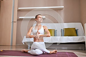 Young short-haired woman exercise at home in bright room