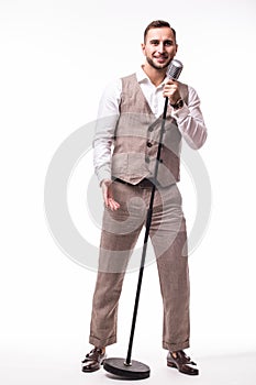 Young showman in suit singing with emotions gesture over the microphone with energy.