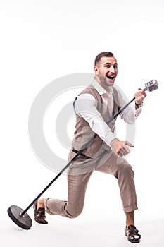 Young showman in suit singing with emotions and pointed gesture over the microphone with energy