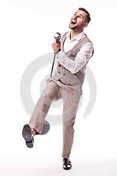 Young showman in suit singing with emotions and pointed gesture over the microphone with energy