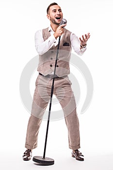 Young showman in suit singing with emotions and pointed gesture over the microphone with energy