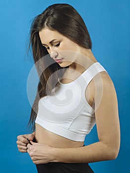 Young shy beautiful woman over blue background