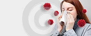 Young sick girl sneezes in a scarf surrounded by infection and virus cells on a gray background