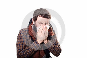 Young sick and ill man in bed holding tissue cleaning snotty nose having temperature feeling bad infected by winter