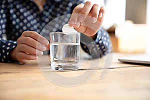 Sick woman drop effervescent aspirin into water glass take medicine