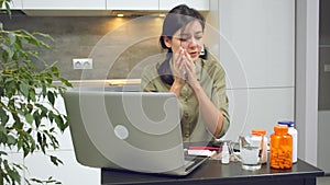 Young sick woman calling a doctor to get an online consultation during her illness at home. Telemedicine.