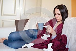 Young sick woman with cold and flu she is measuring temperature