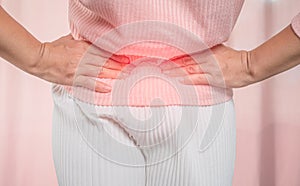 Young sick woman with hands holding her belly suffering menstrual period pain at home. Gynecology and female health concept photo