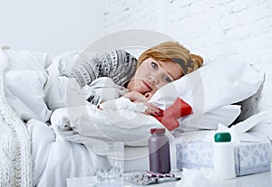 Young sick woman lying on bed ill feeling bad looking feverish and weak suffering winter flu virus