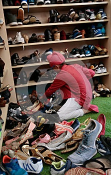 Young Sikh ranging shoes at wardrobe inside a temple in Mallorca