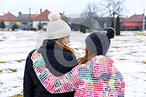 Young sisters walking in the park in wintertime