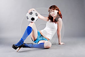 Young sitted girl and soccer ball
