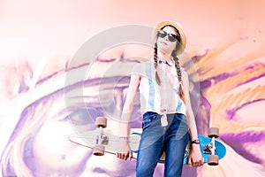 Young skateboard girl holding her longboard outdoors