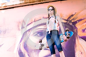 Young skateboard girl holding her longboard outdoors