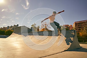 Young skateboarder flies with his board on the ramp of a skate park