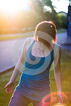 Young skateboarder girl looking down on her skateboard in a park, outdoors.