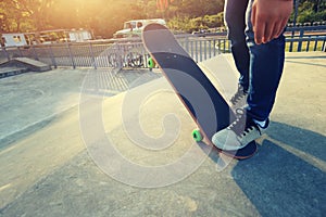 Young skateboarder legs riding skateboard at skatepark