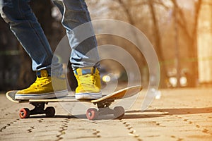 Young skateboarder legs skateboarding at skatepark outdoors