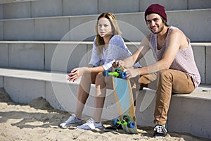 Young skateboarding couple on a beach