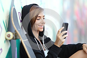 Young skater happy teen girl using a smart phone