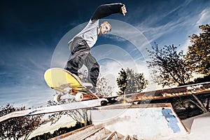 Young skater making a grind on Skatepark during sunset photo