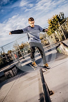 Young skater making a Grind on Skatepark during sunset