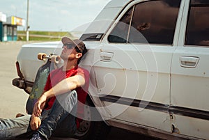 Young skater in the red shirt resting at the old cars, the journey to longbone, photo
